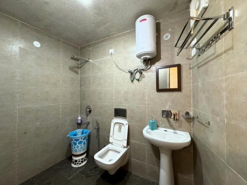 a bathroom with a toilet and a sink at Wanderlust Mukteshwar in Mukteswar