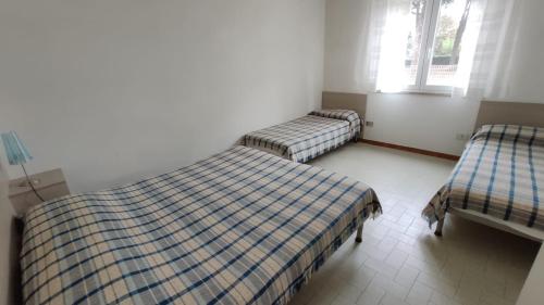 2 camas individuais num quarto com 2 janelas em Villa ANNA 3 em Lignano Sabbiadoro