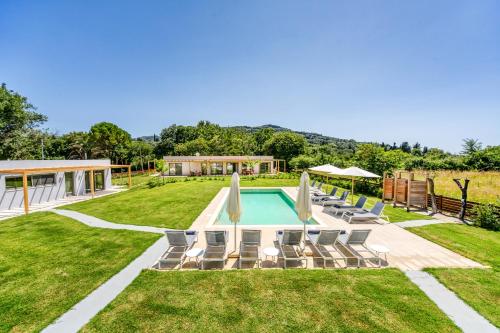 een achtertuin met een zwembad en stoelen bij Kumquart estate- Bergamot in Aspiotádes