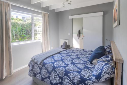 Un dormitorio con una cama azul y blanca y una ventana en A Resort Gem With A Pool en Cape St Francis
