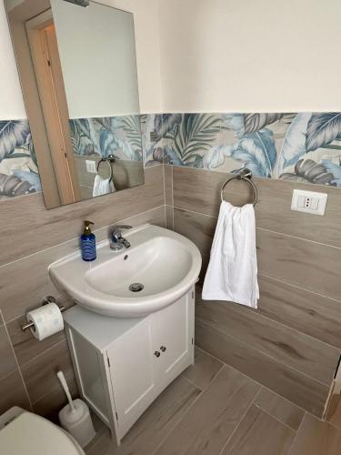 a bathroom with a sink and a mirror and a toilet at Casa vacanza Sofiu' in Mazara del Vallo