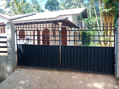 um portão preto em frente a uma casa em Challsvilla Holiday Family Rooms Matara em Kekanadura