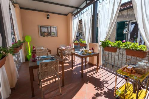 einen Balkon mit Tischen, Stühlen und Pflanzen in der Unterkunft B&B Il Grifone in Pistoia