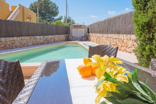 uma mesa com laranjas ao lado de uma piscina em Ferienhaus mit Privatpool für 6 Personen ca 120 qm in Sa Rapita, Mallorca Südküste von Mallorca em Sa Ràpita