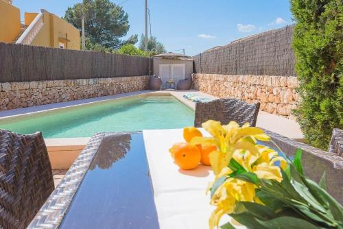 - une table avec des oranges à côté d'une piscine dans l'établissement Ferienhaus mit Privatpool für 6 Personen ca 120 m in Sa Rapita, Balearen Mallorca, à Sa Ràpita