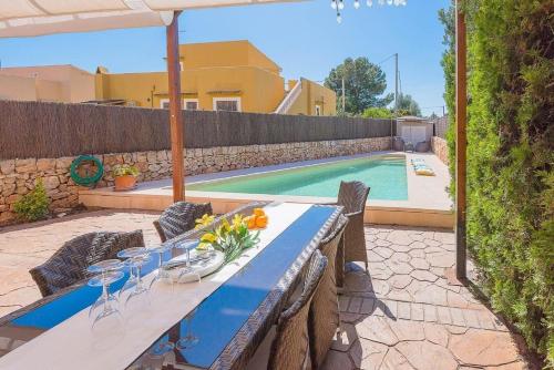 une table bleue avec des chaises et une piscine dans l'établissement Ferienhaus mit Privatpool für 6 Personen ca 120 m in Sa Rapita, Balearen Mallorca, à Sa Ràpita