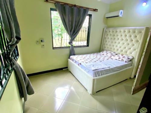 a small bedroom with a bed and a window at A private self contained room in a home away from home in Dar es Salaam