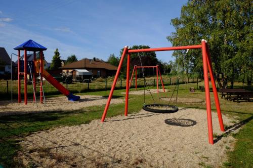 a playground with two swings and a slide at Ferienwohnung-zum-Kueppchen in Münstermaifeld