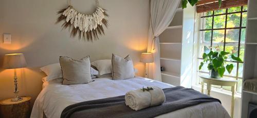 a bedroom with a bed with two towels on it at SAGE Cottage Bloubergstrand in Cape Town