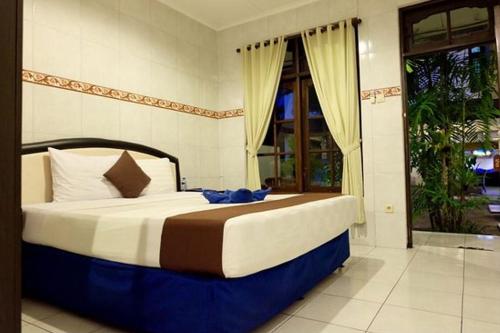 a large bed in a room with a window at LH - Norm House in Kuta
