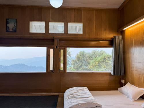 Wanderlust Mukteshwar في مكتزور: غرفة نوم مع سرير بطابقين مع نافذة كبيرة