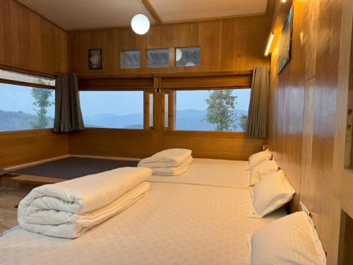 a bedroom with two beds in a boat at Wanderlust Mukteshwar in Mukteswar