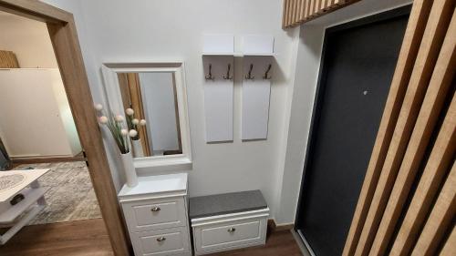 a hallway with a mirror and a dresser and a door at Słoneczne Mieszkanko Przymorze 2 km do plaży in Gdańsk