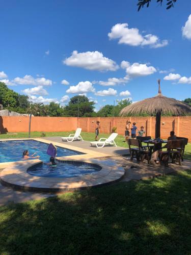a group of people sitting around a swimming pool at Quinta Dulce Morada in Capiatá
