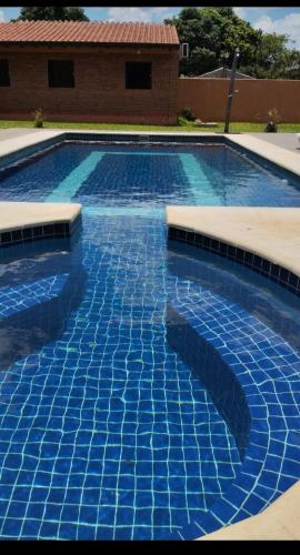 a swimming pool with blue tiles on it at Quinta Dulce Morada in Capiatá