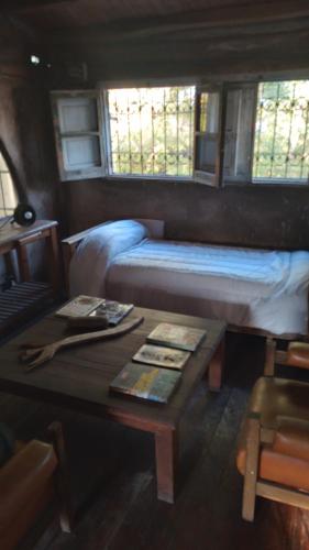 Zimmer mit einem Bett und einem Tisch mit einem Couchtisch in der Unterkunft HOSTEL CHACRAS in Ciudad Lujan de Cuyo