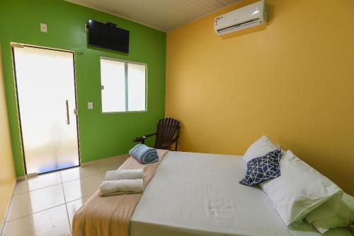 een slaapkamer met een groot bed met groene muren bij Suíte Sapoti - Quarto Casal in Barreirinhas