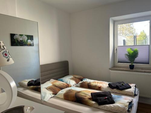 1 Schlafzimmer mit 2 Betten vor einem Spiegel in der Unterkunft Appartement Wörthersee in Klagenfurt am Wörthersee