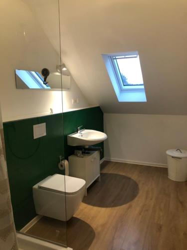 a bathroom with a toilet and a sink and a window at 4 Zimmer-Komfortwohnung mit viel Platz in Haltern in Haltern