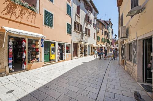Una calle en una ciudad vieja con gente caminando por ella en Ferienwohnung für 4 Personen ca 60 qm in Rovinj, Istrien Istrische Riviera, en Rovinj