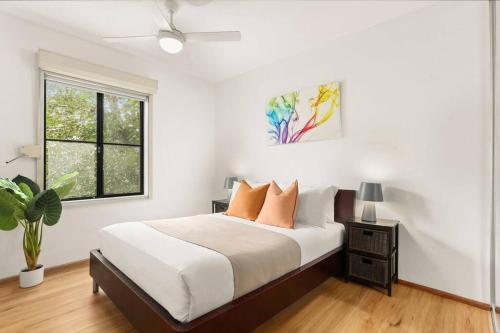 Cosy Inner City Abode - 1 Bed Woolloomooloo في سيدني: غرفة نوم بيضاء بها سرير ونافذة