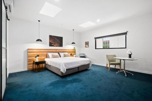 a bedroom with a bed and a desk and a table at The Electric Hotel in Geelong