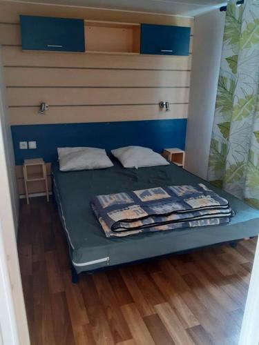 Ce lit se trouve dans un dortoir doté de murs bleus et de parquet. dans l'établissement Mobilhome L'Oasis Camping le Clos Cottet, à Angles