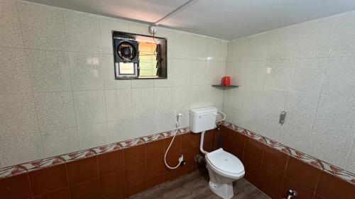 a bathroom with a toilet and a camera on the wall at Coco Hut , Devbaug in Malvan