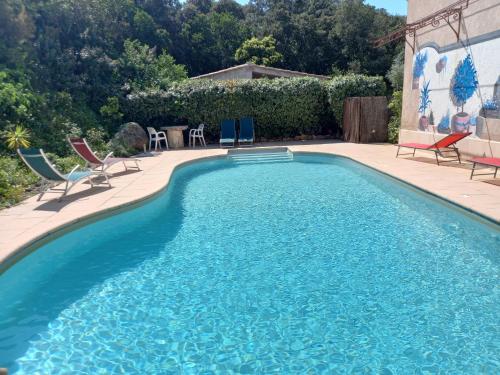 une piscine avec des chaises et une table dans l'établissement mini villa studio 1 pièce 19 m2 pour 2 personnes piscine partagée climatisation, à Porto-Vecchio