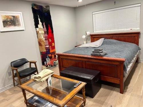 a bedroom with a bed and a table and a chair at A Luxury Master Bedroom in a Condo in Los Angeles