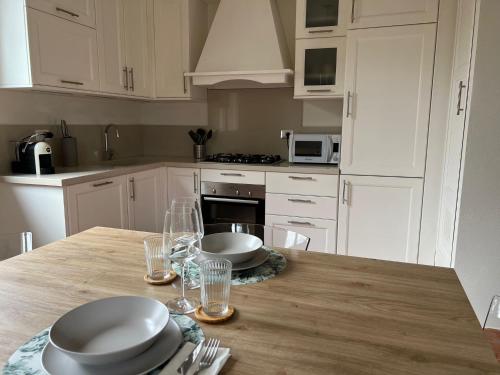 a kitchen with white cabinets and a wooden table at Il nido in Cerreto Guidi