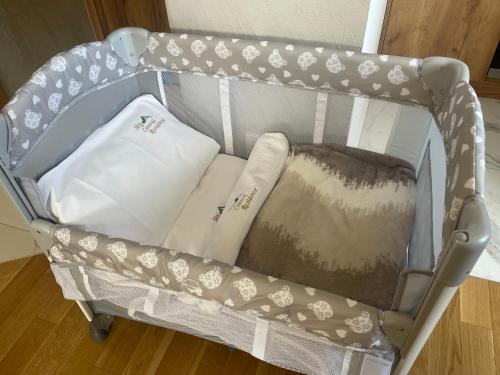 a baby crib with pillows in it at Lux apartment Sky Central Residence Zlatibor in Zlatibor
