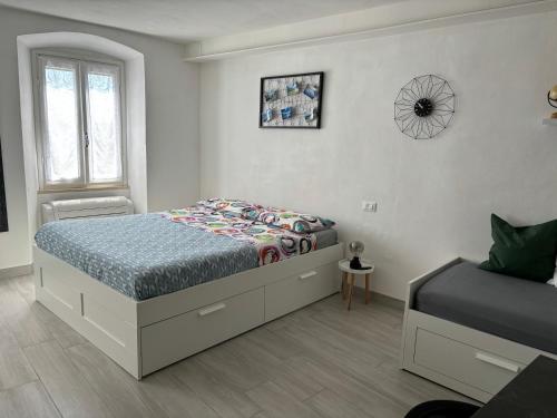 a white bedroom with a bed and a window at Chez Ary: Sulla strada del Lago in Clusane sul Lago