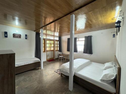 a bedroom with two bunk beds and a desk at Wanderlust Mukteshwar in Mukteswar