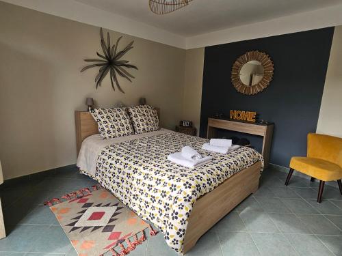 1 dormitorio con cama, espejo y silla en L'Orée du Bois en Coutiches