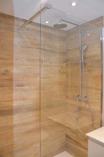 a bathroom with a shower with a wooden wall at Apartament na Starówce Grobla I in Gdańsk