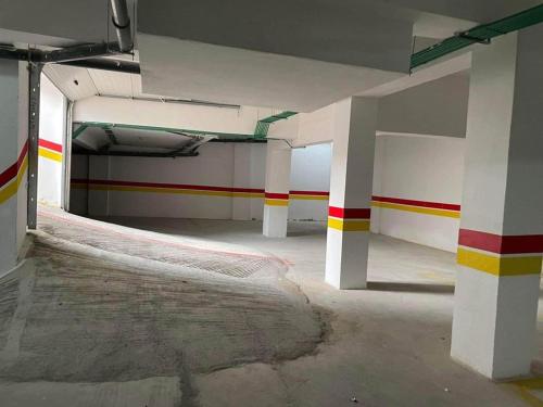 an empty parking garage with red yellow and white stripes at RIMAL MAHDIA in Kenitra