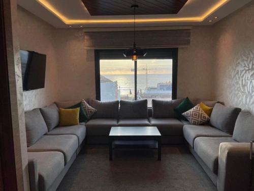 ein Wohnzimmer mit einem Sofa und einem Tisch in der Unterkunft RIMAL MAHDIA in Kenitra