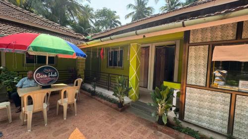 a man sitting at a table outside of a food truck at Coco Hut , Devbaug in Malvan