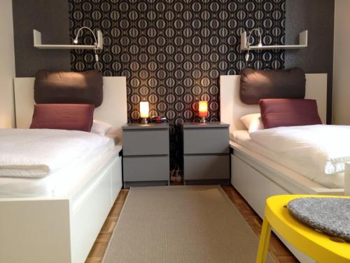 two beds in a room with two tables with candles at HertenFlats - Rooms & Apartments - Kreis Recklinghausen in Herten