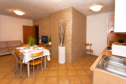 a kitchen and dining room with a table and chairs at Residence Delle Rose in Tremosine Sul Garda