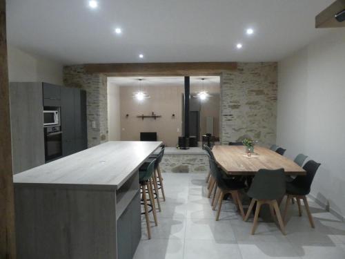 a kitchen with a large wooden table and chairs at Gîte La Maijou d'Aômés in Saint-Martin-le-Vieux