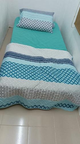 two beds with blue and white sheets on the floor at Sutera Homestay in Sungai Petani