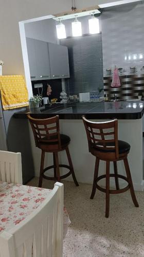 a kitchen with two chairs and a kitchen counter at Sutera Homestay in Sungai Petani