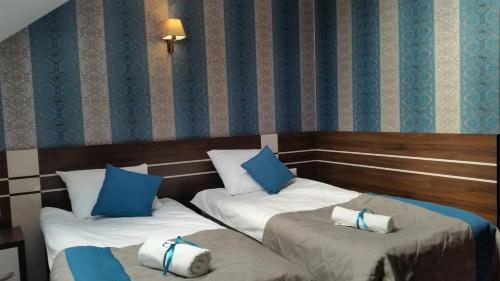 2 camas en una habitación con almohadas azules y blancas en Hotel Impressa en Niedrzwica Duża