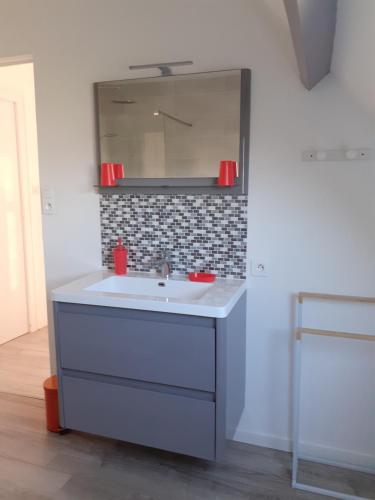 a bathroom with a sink and a mirror at maison proximité mer in Plozévet