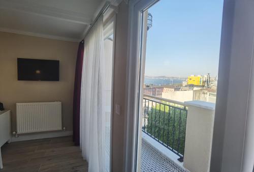 um quarto com uma varanda com uma grande janela em Mr. Bird Hotel em Istambul