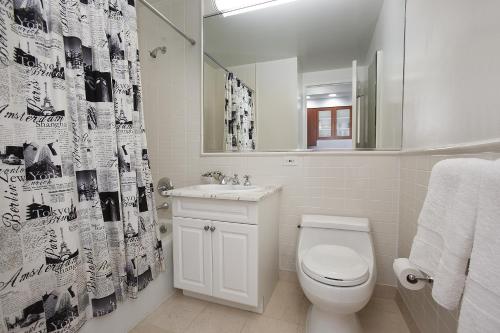 uma casa de banho com um WC, um lavatório e uma cortina de chuveiro em Lux Studio West Village em Nova York