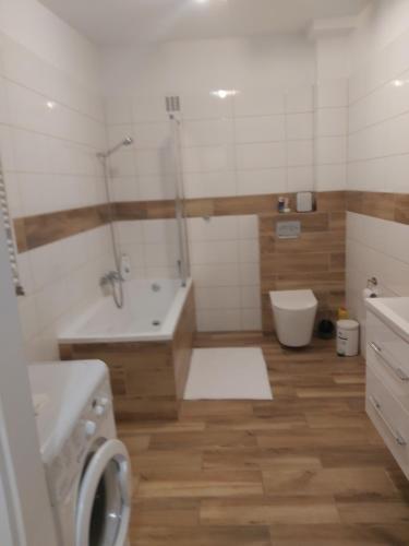 a bathroom with a tub and a toilet and a sink at Przy Parku in Wyszków