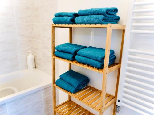 - un porte-serviettes en bois avec des serviettes bleues dans la salle de bains dans l'établissement Le Lion d'or - Parking - Netflix - Wifi - Nerf, à Bussy-Saint-Georges